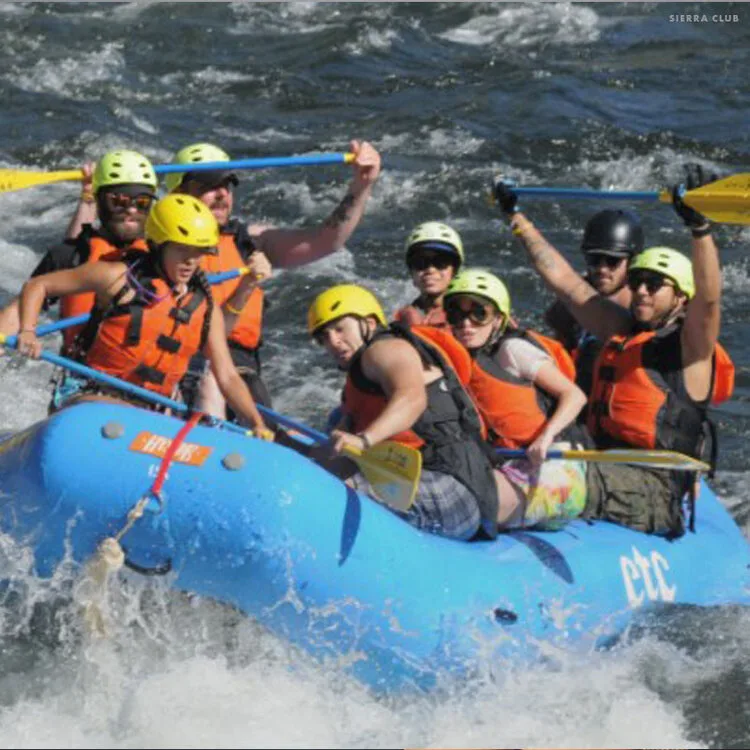 Veterans in helmets paddling a raft through whitewater with the Sierra Club Military Outdoors program