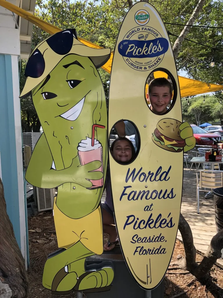 Children posing in a surfboard face cutout at Pickle's in Seaside, Florida, from Tom Owen's family trip