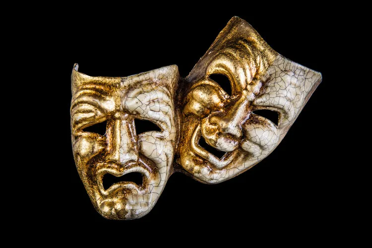 Gold comedy and tragedy theater masks on a black background