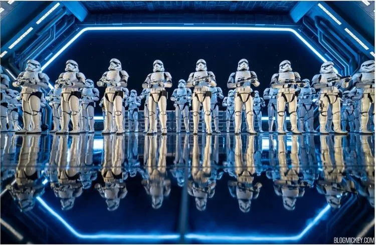 Rows of stormtroopers reflected in a glowing hangar in Star Wars: Rise of the Resistance