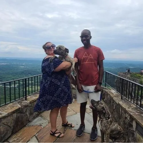 Couple posing with their dogs at a stone overlook at Rock City on Lookout Mountain, Georgia