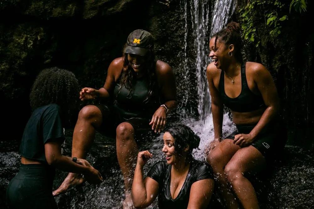 Black People Who Hike members laughing together under a waterfall