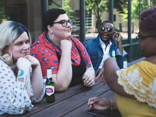 Friends chatting over drinks at an outdoor patio table