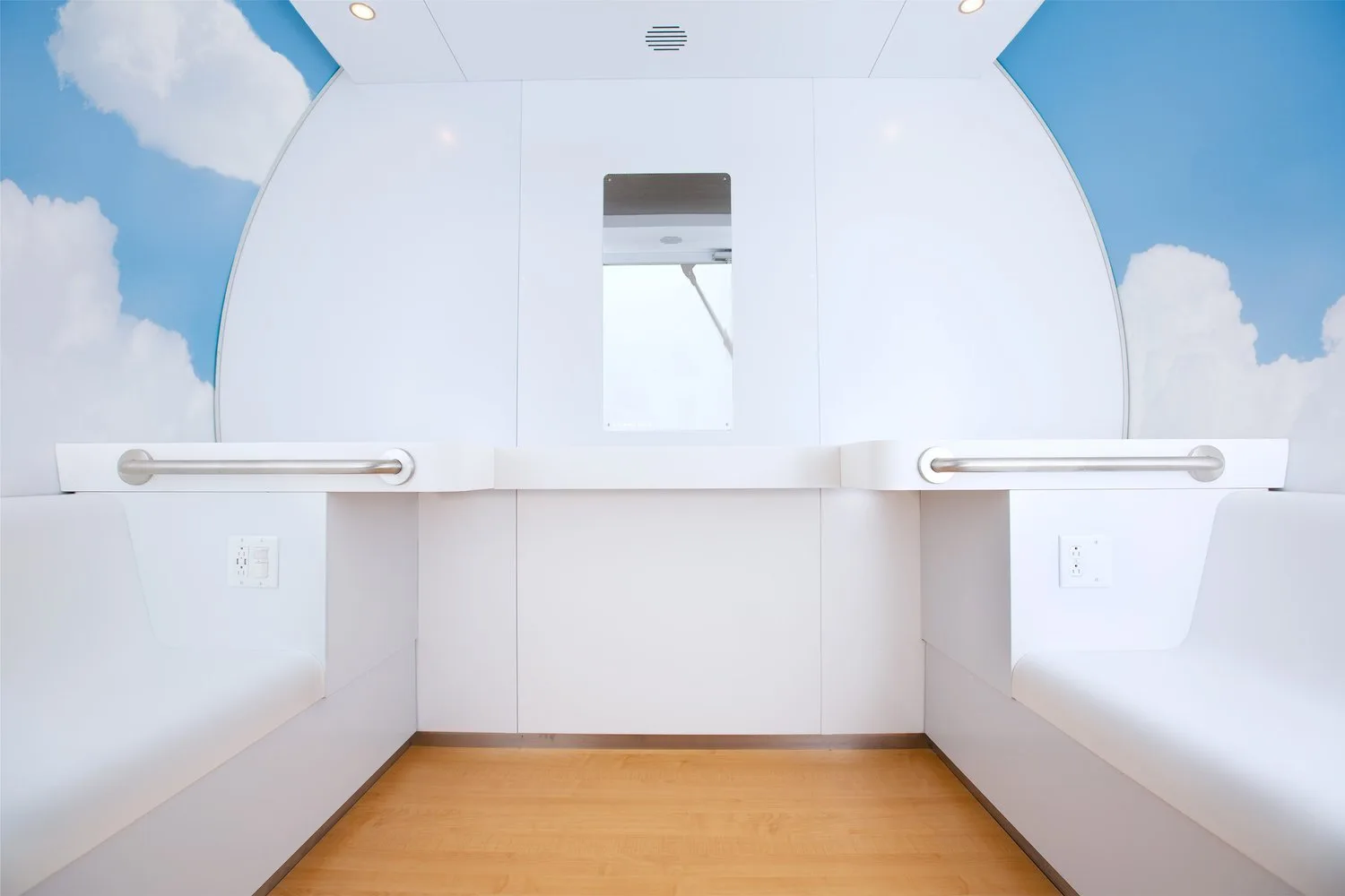Interior of a Mamava lactation pod with two benches, a fold-down counter and outlets