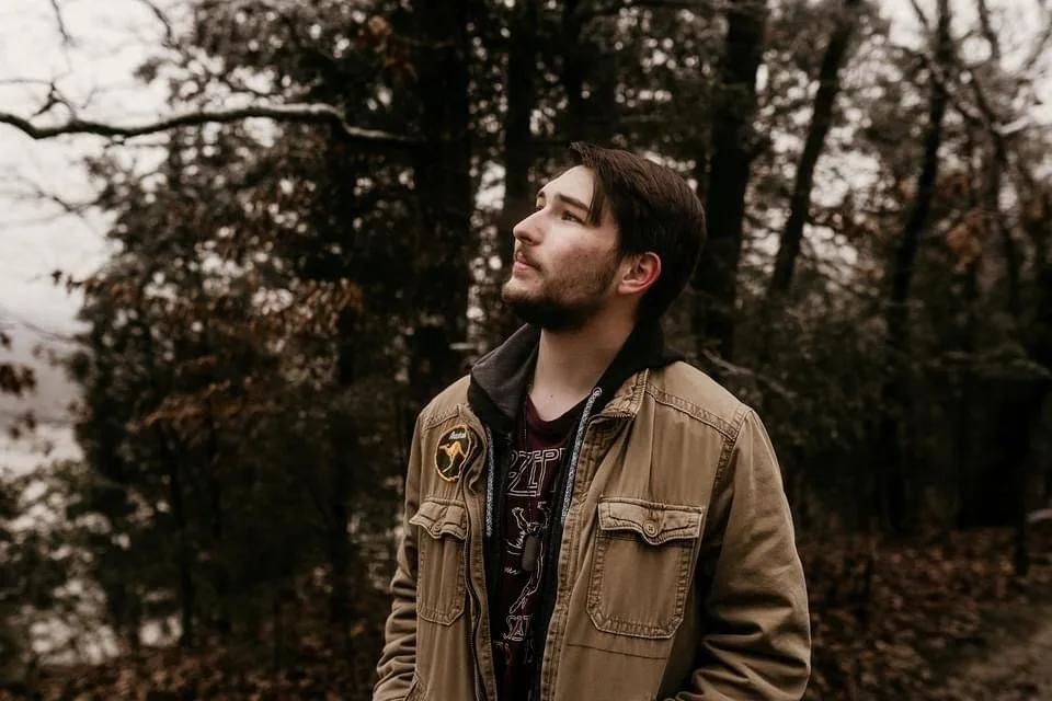 Geoffrey Dugopolski standing in an autumn forest in a canvas jacket