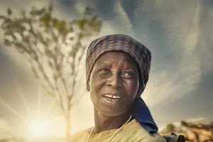 Portrait of an older woman in a head wrap at sunset in a village in Botswana