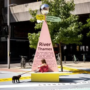Pink River Thames pyramid wayfinding marker with a mirrored ball and bench, part of You Are Here by Charles Holland Architects