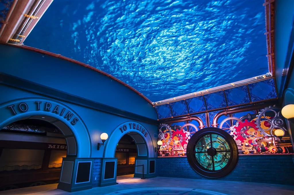 St. Louis Aquarium lobby with an overhead water video ceiling, To Trains archways and a gear-framed clock habitat