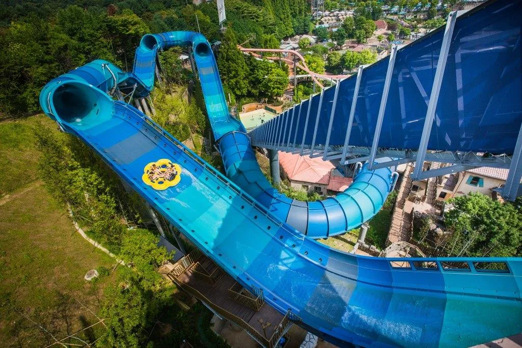 A yellow raft heads down the blue waterslide of Everland's Mega Storm