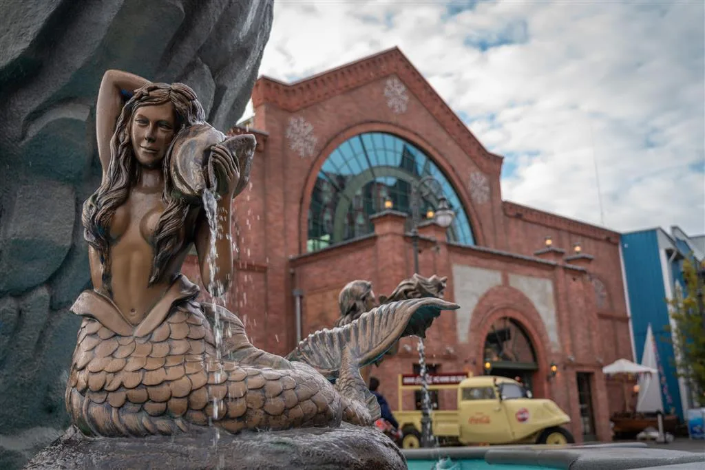 Mermaid fountain sculpture in front of the red-brick entrance building of Rulantica water park at Europa-Park