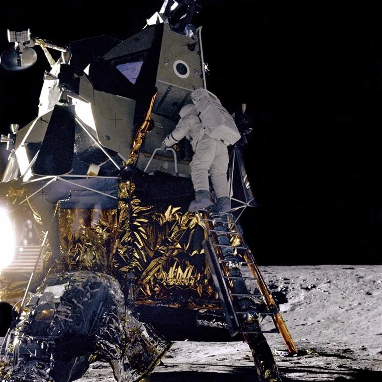 Apollo 12 astronaut descending the lunar module ladder onto the surface of the Moon