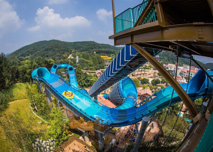 A yellow raft heads down the blue waterslide of Everland's Mega Storm
