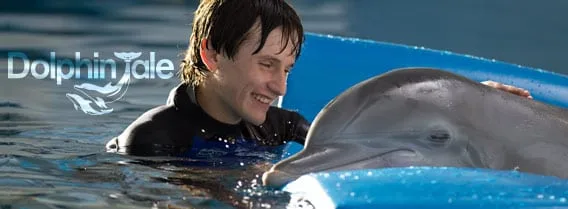 Dolphin Tale movie banner showing a boy in the water smiling beside a dolphin