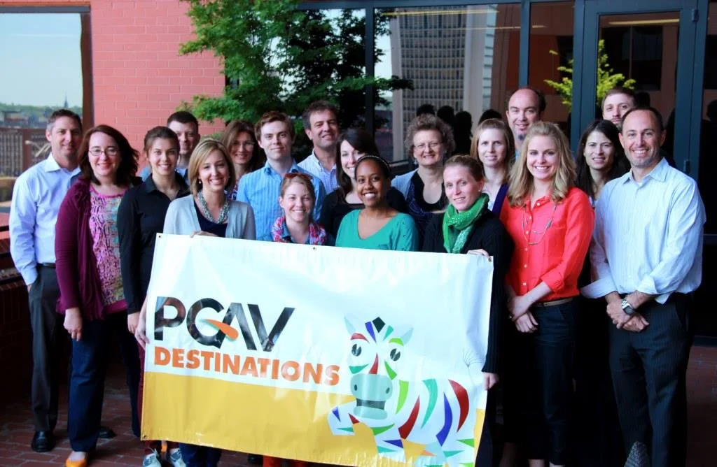 PGAV's team poses with the Spot the Zebra "PGAV Destinations" banner at the St. Louis headquarters
