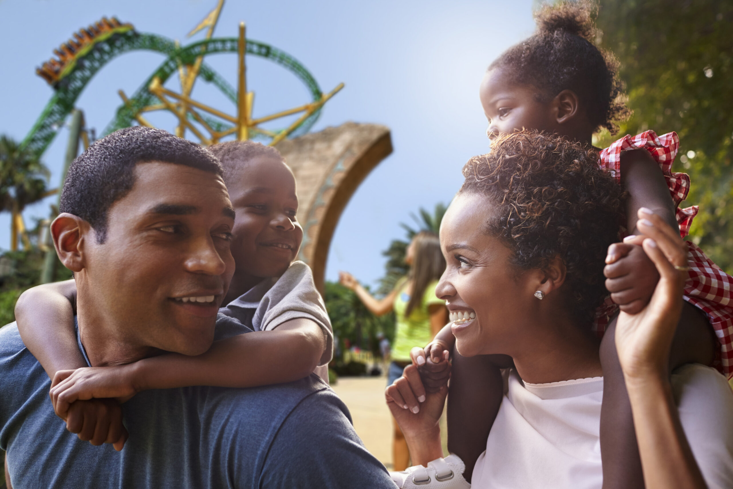African American parents giving children piggyback rides at Cheetah Hunt Busch Gardens Tampa