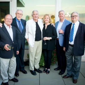 Six PGAV colleagues posing together at an evening rooftop gathering