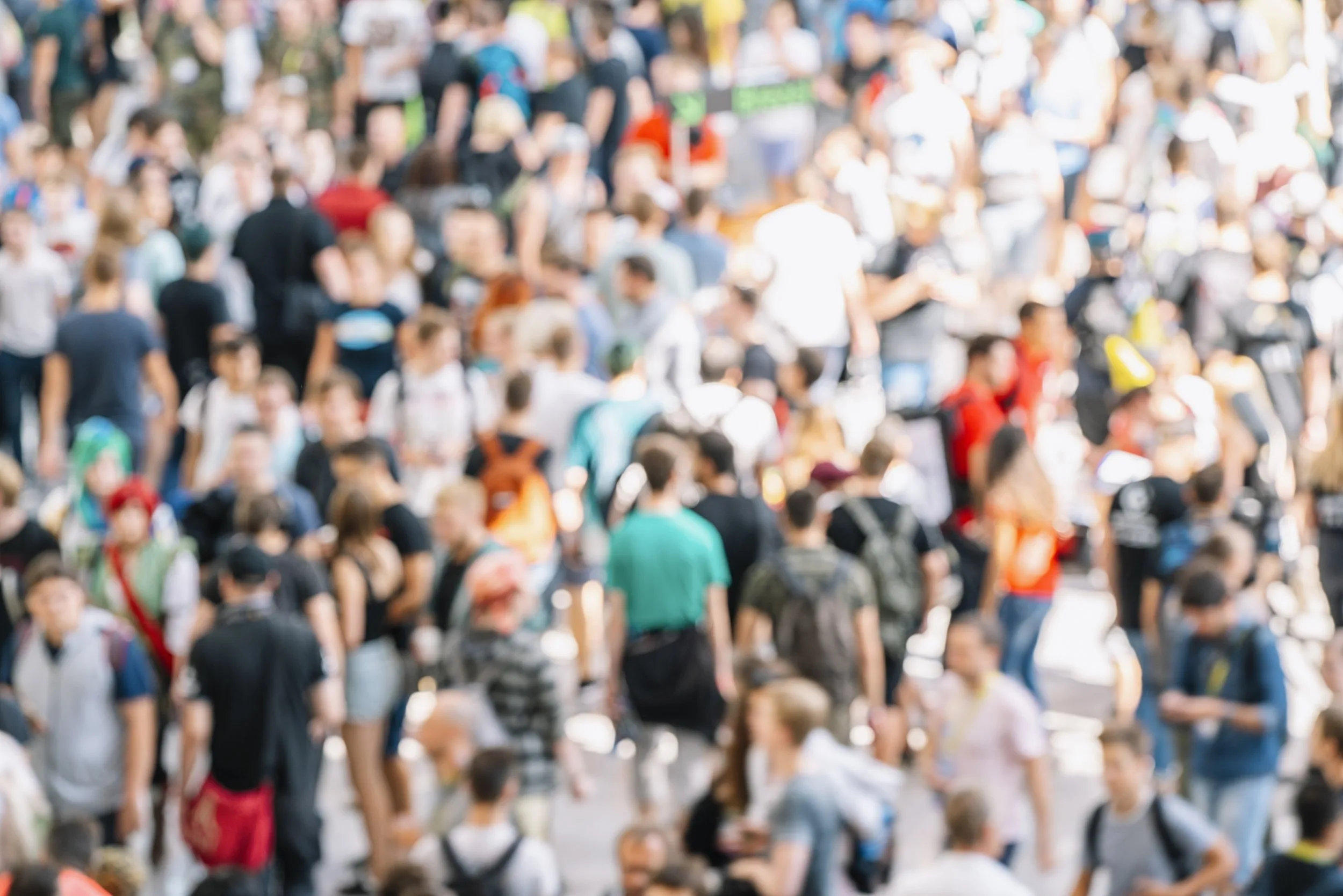 Blurred crowd of people moving through a busy trade fair