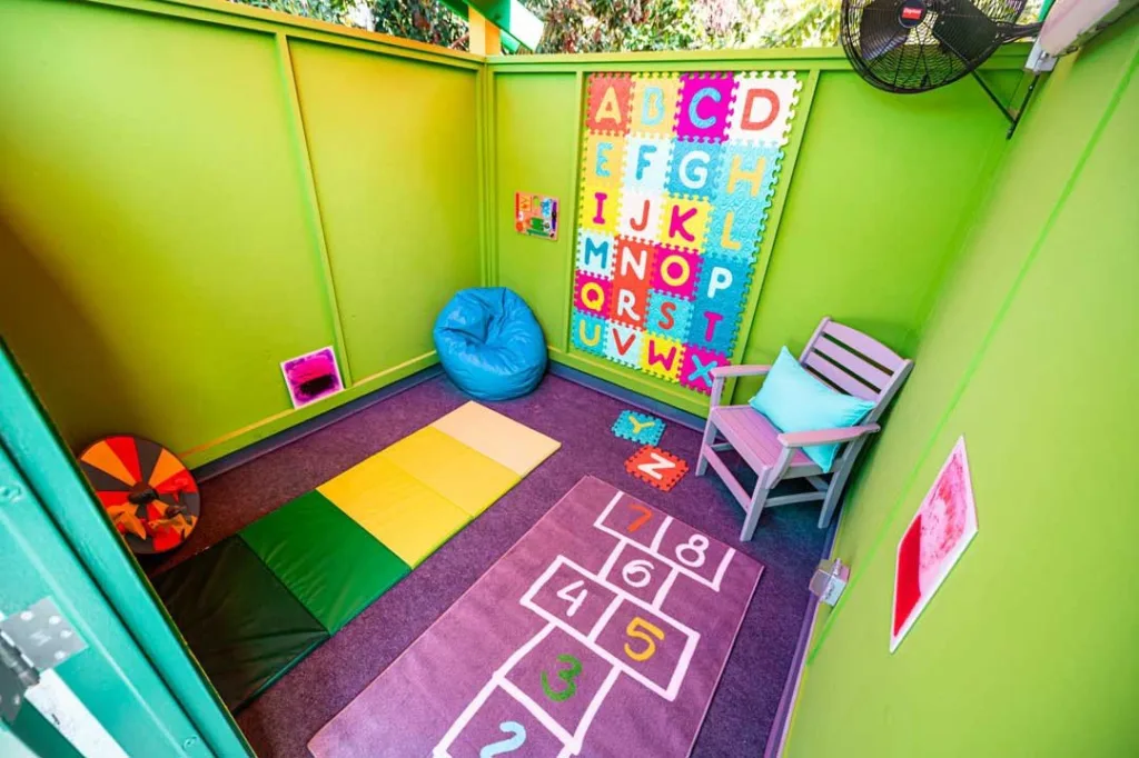 Colorful quiet room with alphabet mats, beanbag and hopscotch rug at Sesame Place San Diego