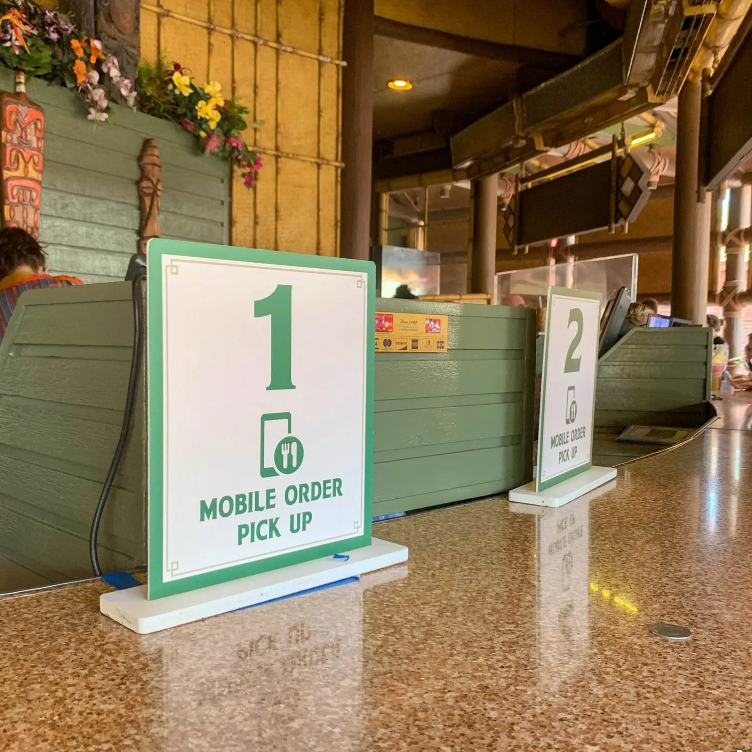 Mobile Order Pick Up signs on the counter at Aloha Isle Refreshments in Magic Kingdom