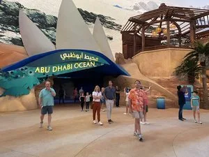 Visitors walking out of the Abu Dhabi Ocean realm entrance with sail-like forms above at SeaWorld Abu Dhabi
