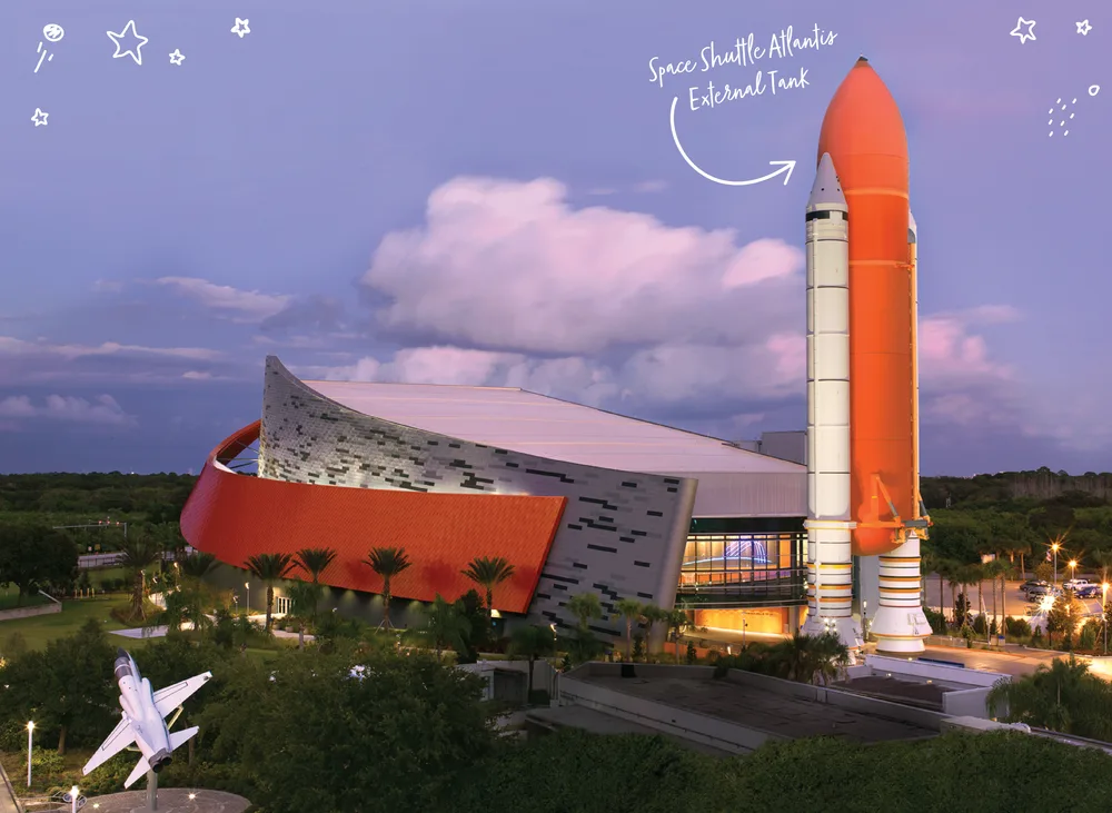 Kennedy Space Center Visitor Complex Space Shuttle Atlantis building with the full-scale external tank and boosters at dusk