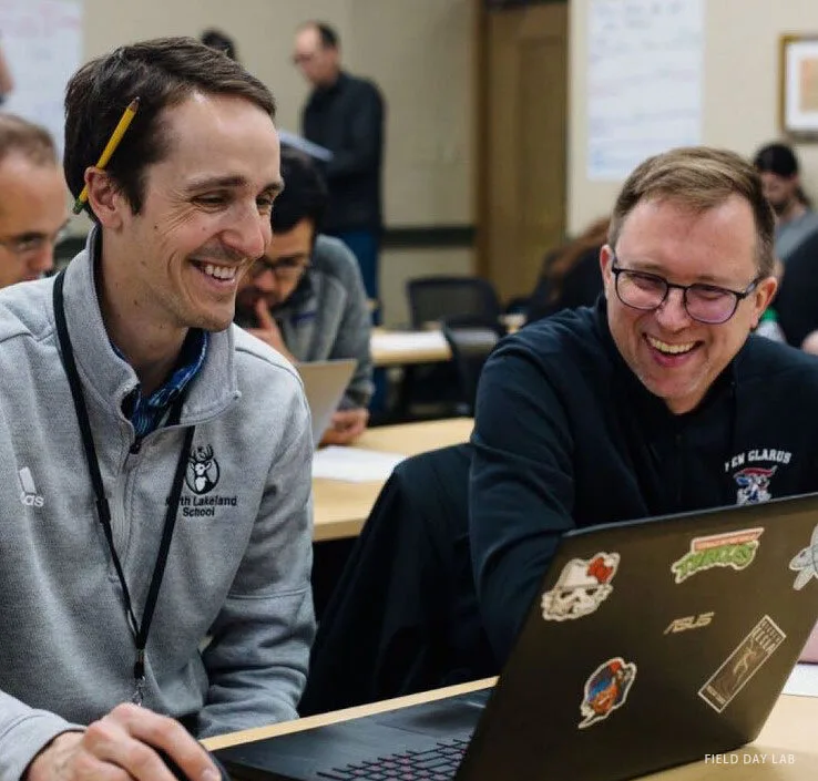 Researchers smiling at laptops during a game design session at Field Day Lab, University of Wisconsin