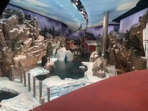 Arctic-themed habitat with snowy rockwork, a pool and red-roofed village scenery at SeaWorld Abu Dhabi