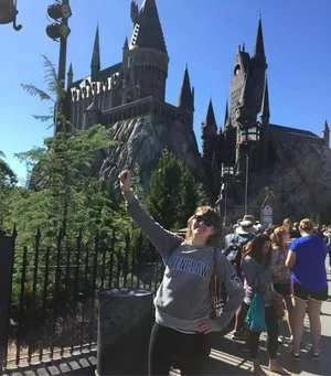 Woman posing in front of Hogwarts Castle at a Wizarding World of Harry Potter park