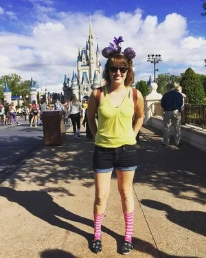 Woman in Minnie ears standing on Main Street with Cinderella Castle behind her