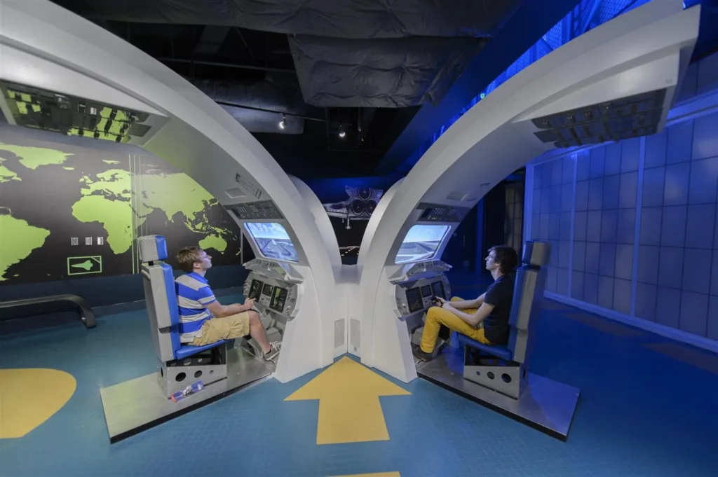 Kids in cockpit-style seats flying a shuttle landing simulator at Kennedy Space Center Visitor Complex