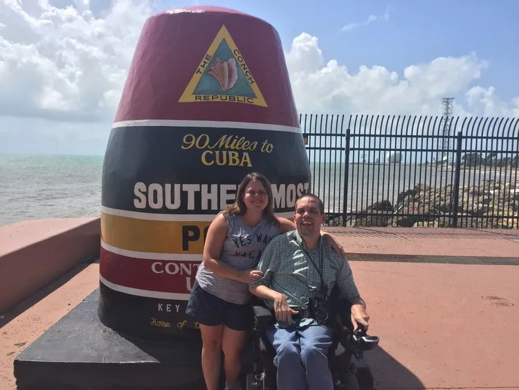 Kim Lackey of Paraquad and her husband at the Southernmost Point buoy in Key West