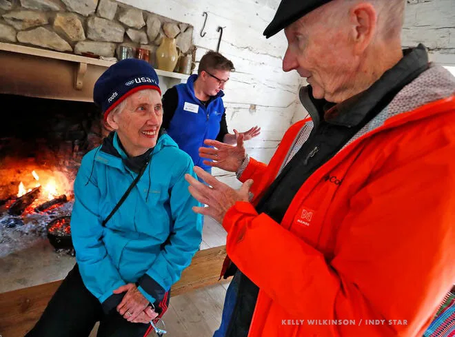 Seniors chatting by a fireplace at Conner Prairie's Memory Cafe for people with dementia and their families