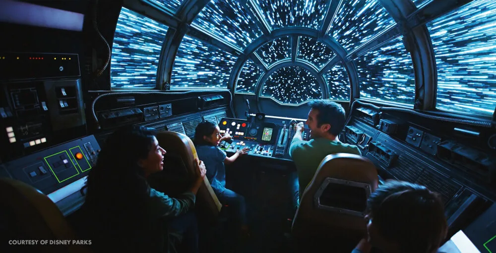 Riders piloting the Millennium Falcon cockpit in Millennium Falcon: Smugglers Run at Star Wars: Galaxy's Edge
