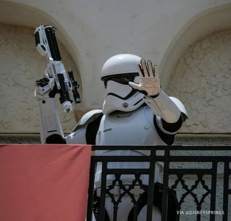 Stormtrooper waving guests back from a balcony to encourage social distancing at Walt Disney World