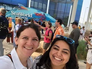Two PGAV team members taking a smiling selfie outside the SeaWorld Abu Dhabi entrance