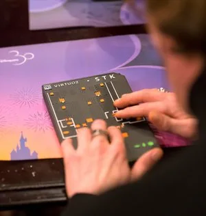 Visitor using a Virtuoz tactile map device over a touchscreen to explore a theme park map by touch