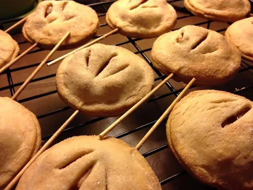 Golden fried hand pies on sticks cooling on a rack at a state fair food stand