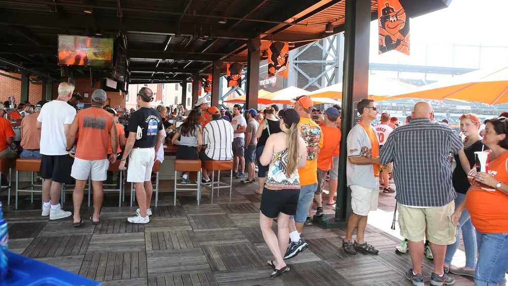 Orioles fans gathering at a covered outdoor bar at the Baltimore Orioles ballpark