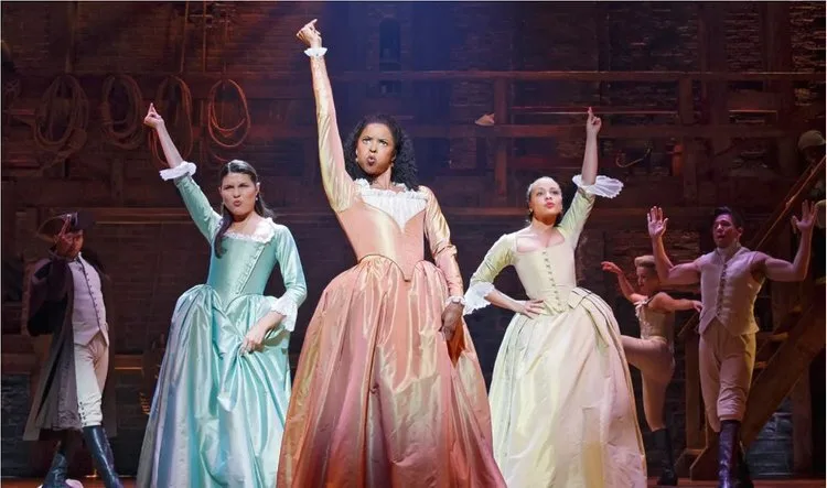 Actresses playing the Schuyler sisters performing on stage in Hamilton on Broadway