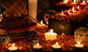 Candles, marigolds and sugar skulls on a Dia de los Muertos ofrenda