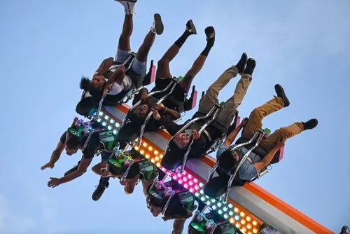 Riders flipped upside down on the Tango thrill ride against the evening sky at the Arizona State Fair