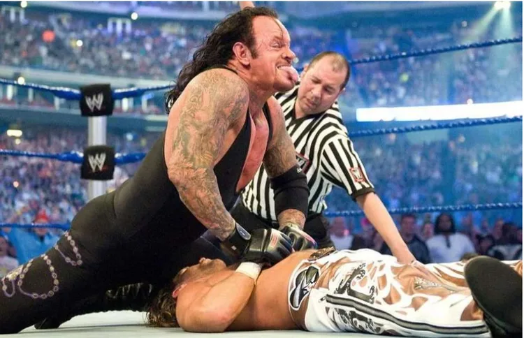 WWE wrestler pinning an opponent as a referee counts the fall in a packed arena