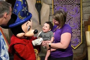 Toddler meeting Sorcerer Mickey Mouse with his parents at a Disney character meal