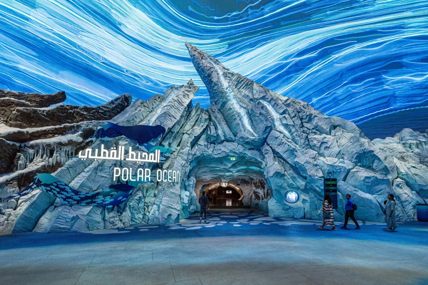 A large visitor portal at SeaWorld Abu Dhabi. Ice and rock form an entryway with the words "Polar Ocean" in English and Arabic protruding from the ice.