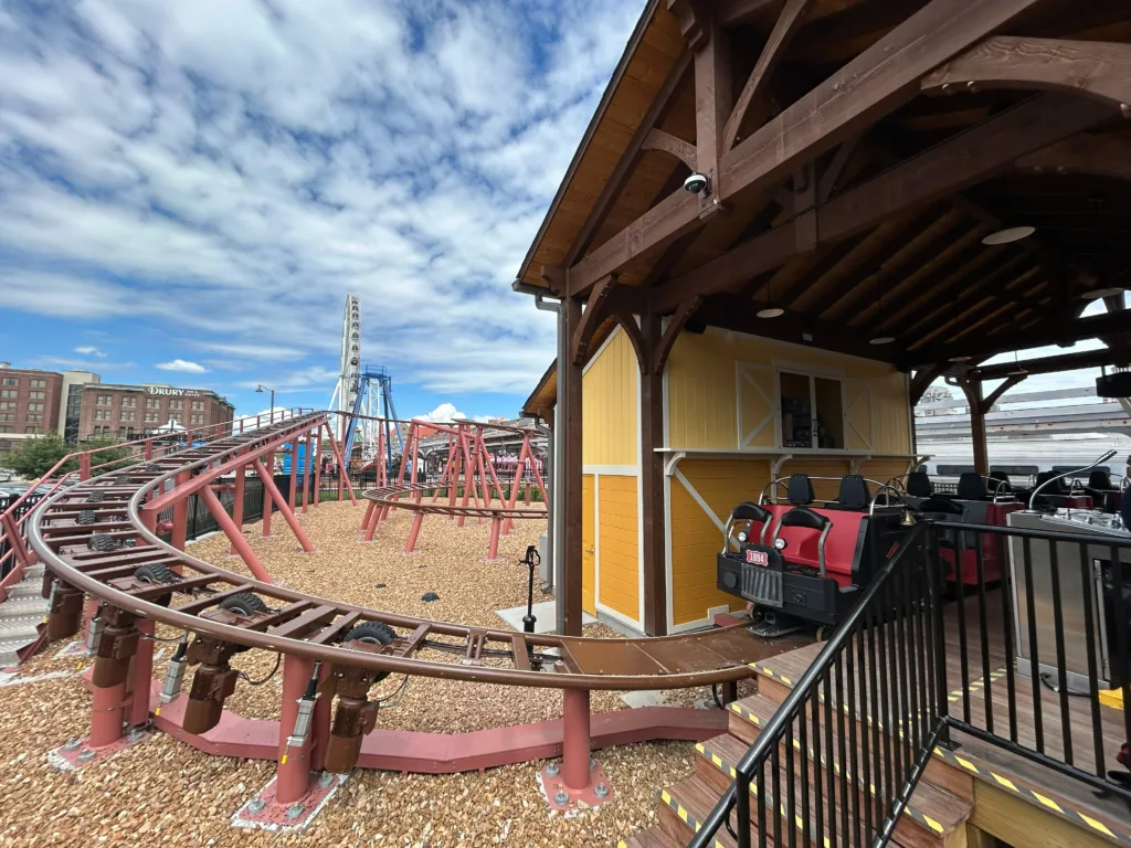 Loco Motion spinning coaster track and yellow station house at St. Louis Union Station