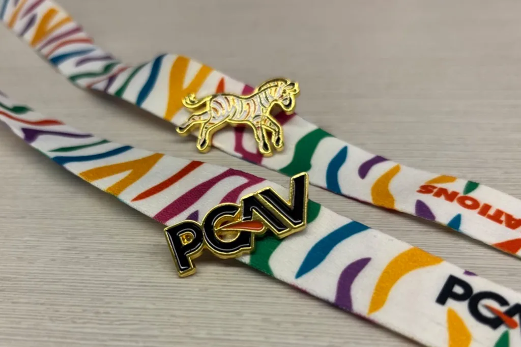 PGAV logo pin and gold zebra Spot pin on rainbow zebra-stripe lanyards