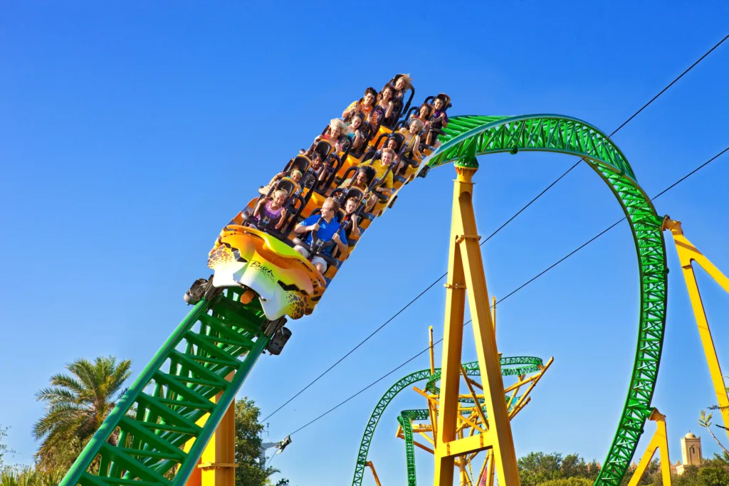 Riders on the Cheetah Hunt roller coaster cresting a green loop at Busch Gardens Tampa