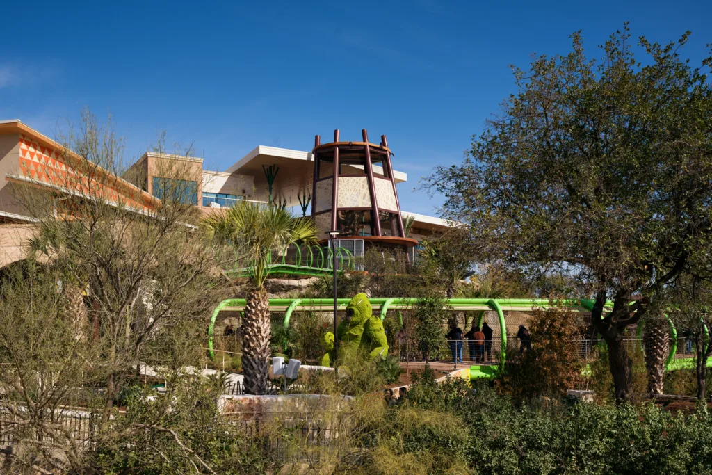 The Ralston event center rising above Congo Falls at San Antonio Zoo, with green gorilla trails in the foreground
