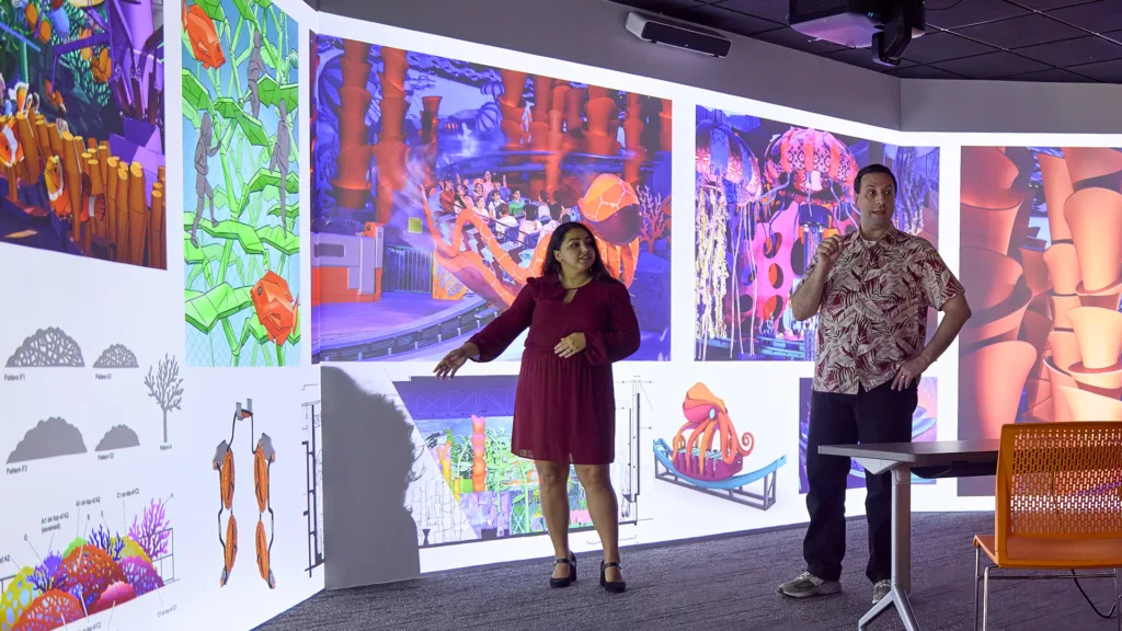 Two presenters speaking in front of projected SeaWorld Abu Dhabi concept art at an AIA St. Louis event