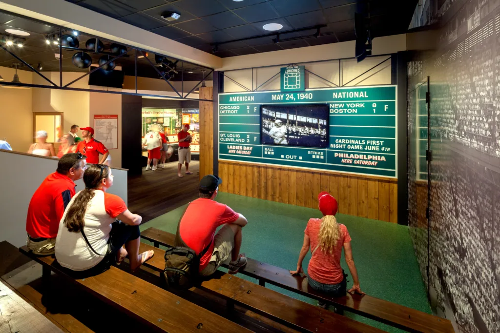 Guests on bleachers watching a vintage 1940 scoreboard display at the Cardinals Hall of Fame and Museum in St. Louis